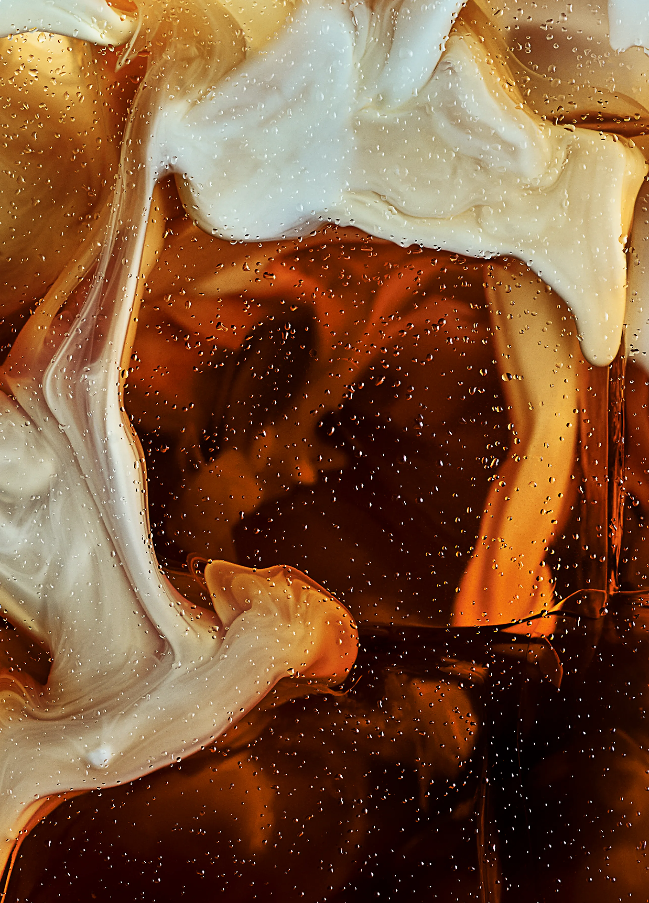 Swirling milk, mixing with a delicious black iced coffee